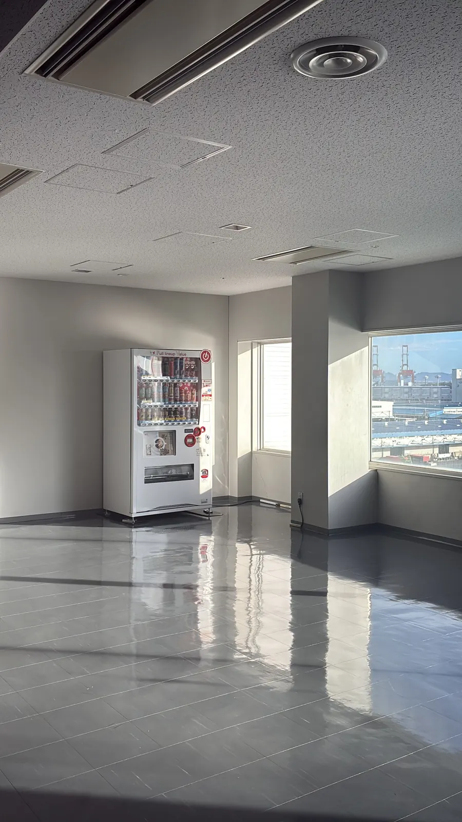 海を望む窓辺に自動販売機が光るATCの空間
